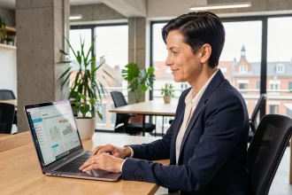 Consultante en stratégie digitale analysant un plan marketing sur ordinateur portable dans un bureau moderne à Nantes